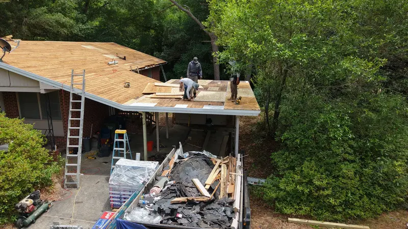 Crew re-decking a carport roof with new plywood after tear-off, old shingles in the trailer, Wilmington, NC